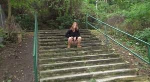 Natural redhead Chrissy Fox squats for a pee on a set of public steps on fangals.org