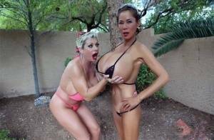 Big titted older women Claudia Marie and Minka kiss outdoors in skimpy bikinis on fangals.org