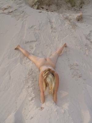 Blonde amateur Sweet Susi gets totally naked on a sandy bank by herself on fangals.org