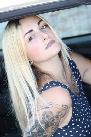 Tattooed girl Medusa Blonde shows her bare feet and ass while in a car on fangals.org