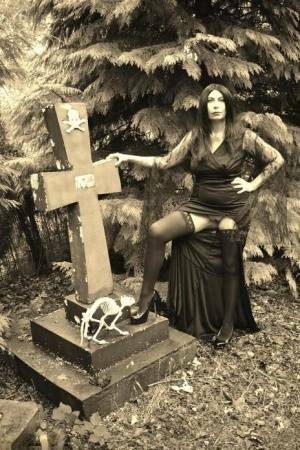 Goth girl Barby Slut bares her big tits and twat atop a casket in the woods on fangals.org