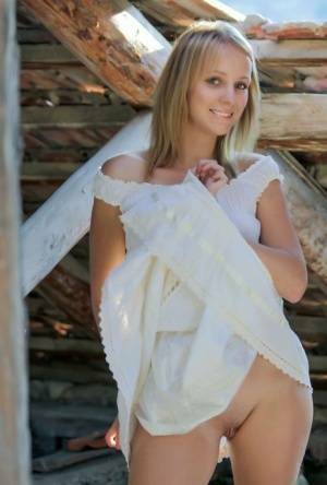 Young blonde Ilona D gets naked in a rustic setting with her boots on on fangals.org