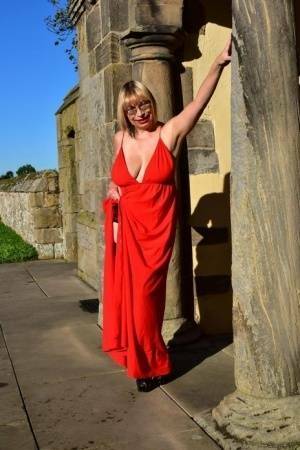 Older blonde Barby Slut doffs a red evening gown to pose nude in hosiery on fangals.org