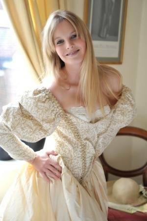 Blonde girl Rose takes off her petticoat to model in a girdle and nylons on fangals.org