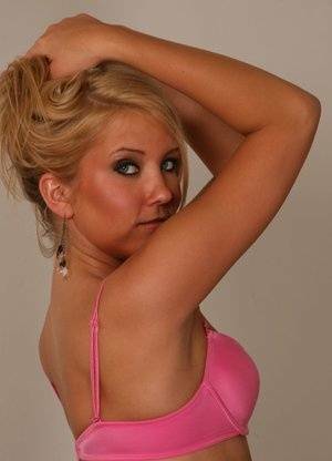 Blonde amateur Jocalynn piles up her hair before getting naked on a bed on fangals.org