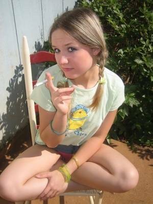 Cute teenage babe Shelby takes a smoke break and flashes us her perky tits on fangals.org