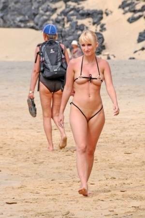 Hot blonde removes a skimpy bikini during a visit to a public beach on fangals.org